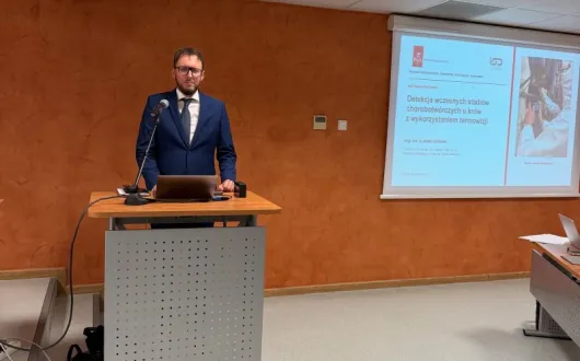 postać doktoranta przy mównicy w sali seminaryjnej wydziału 