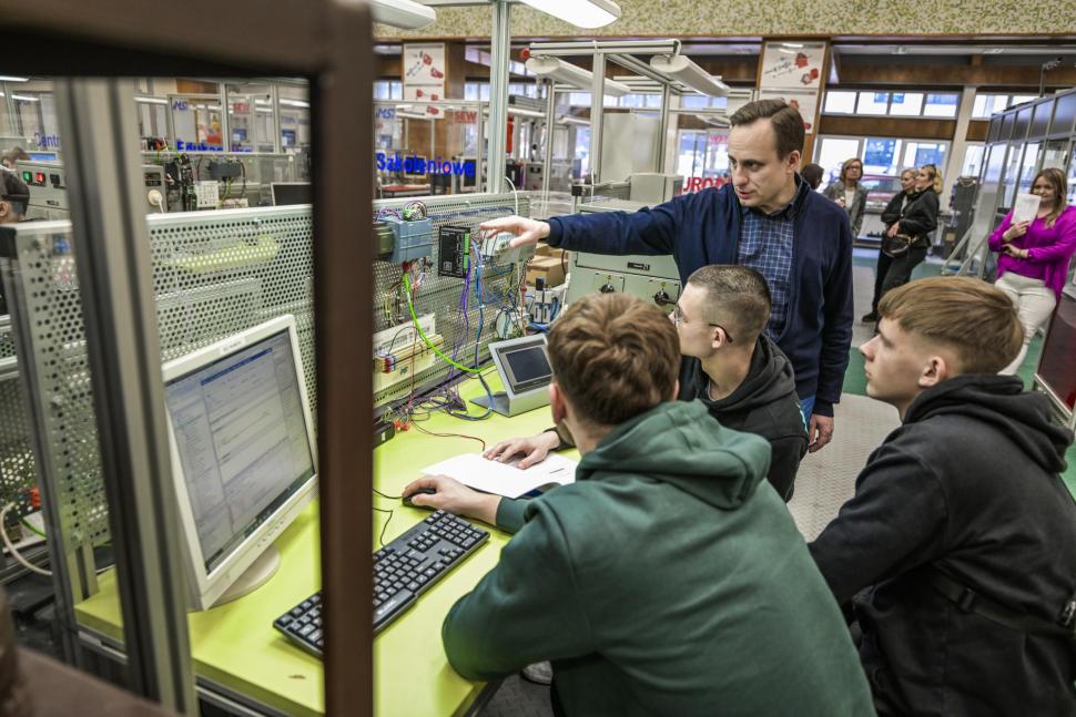 Uczniowie siedzący przy stanowisku dydaktycznym