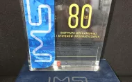 szklana statuetka z napisem 80 lat IMSI